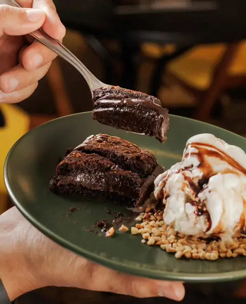 Garfada de brownie com calda de chocolate, sorvete de creme e amendoim no salão da Smash Kings